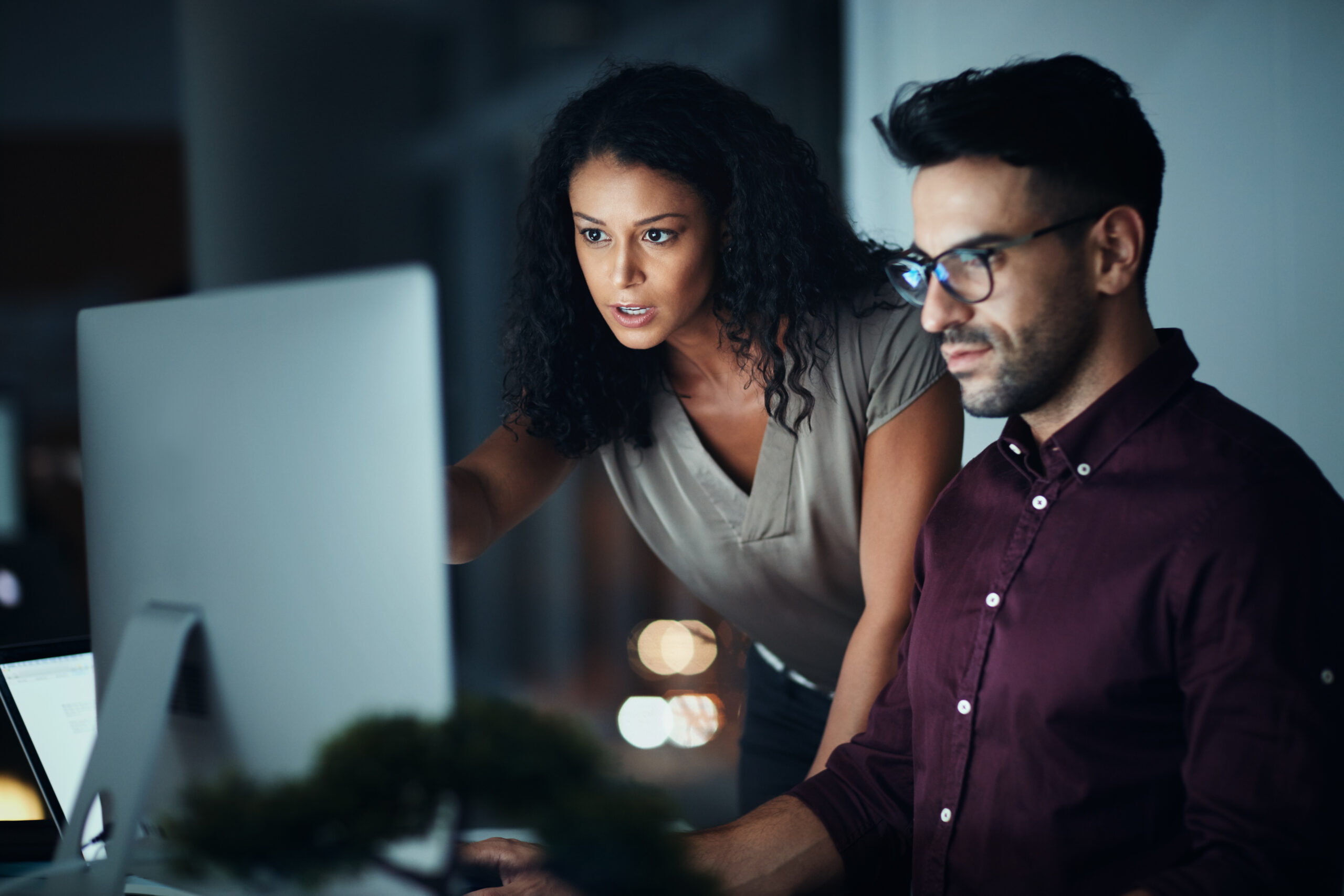 Business people, computer and night team work with planning, collaboration or problem solving at tech company. Developer, programmer and leader with serious for software support and web solution